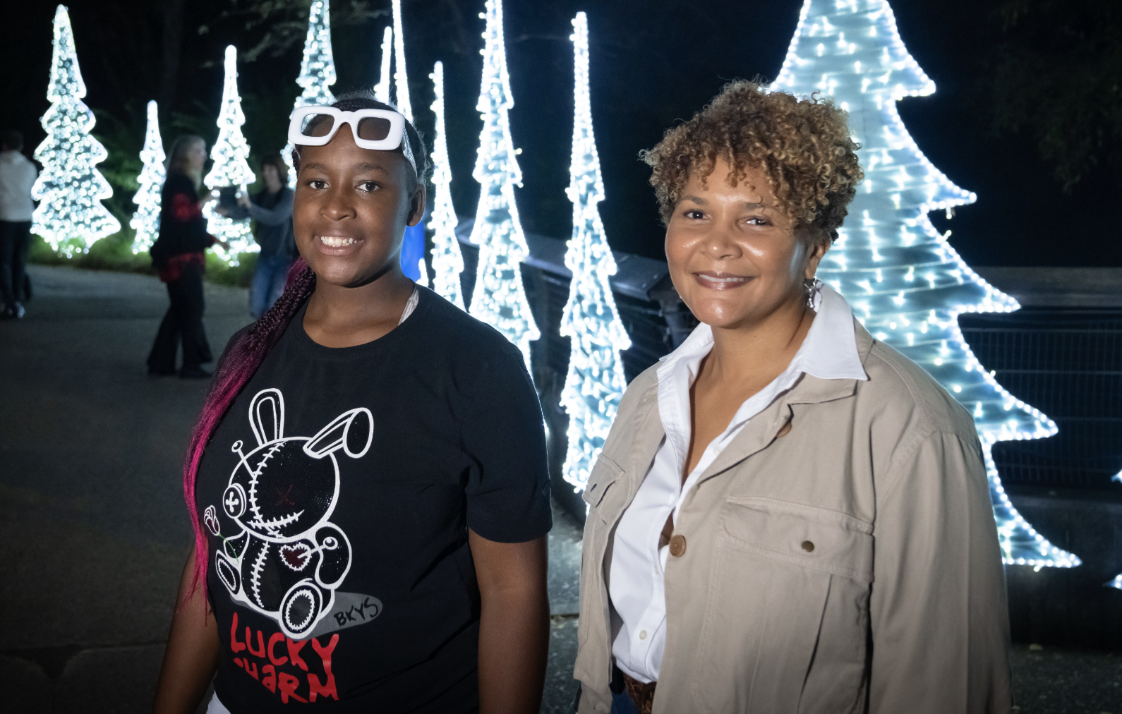Mentor and mentee smiling together at a holiday lights event